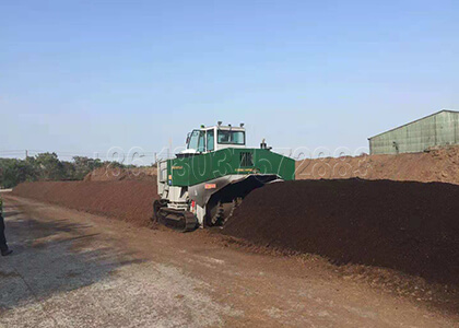 Self-propelled compost turner for organic waste processing